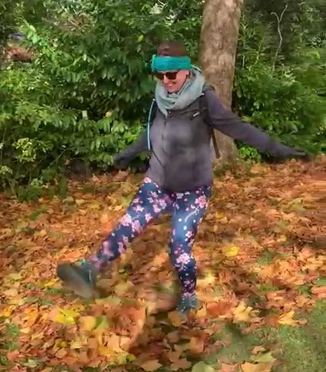 Ruth kicking a pile of autumn leaves